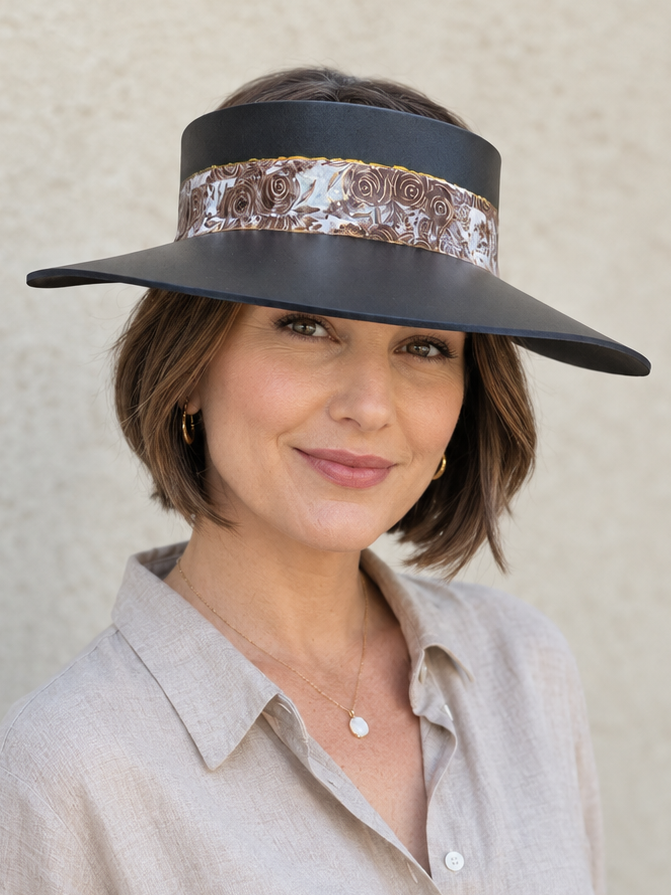 Woman wearing a black visor with a sequin band against a neutral background
