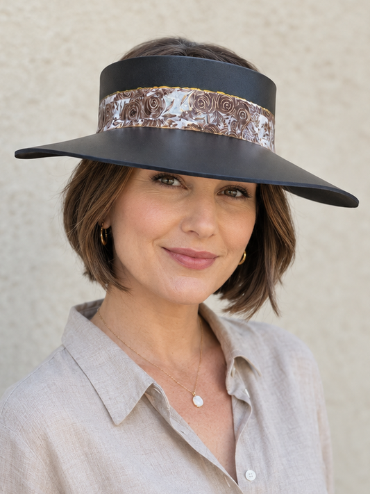 Woman wearing a black visor with a sequin band against a neutral background