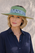 Woman wearing a navy shirt and green visor against a neutral background
