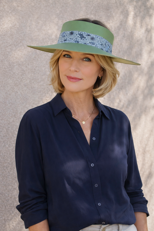 Woman wearing a navy shirt and green visor against a neutral background