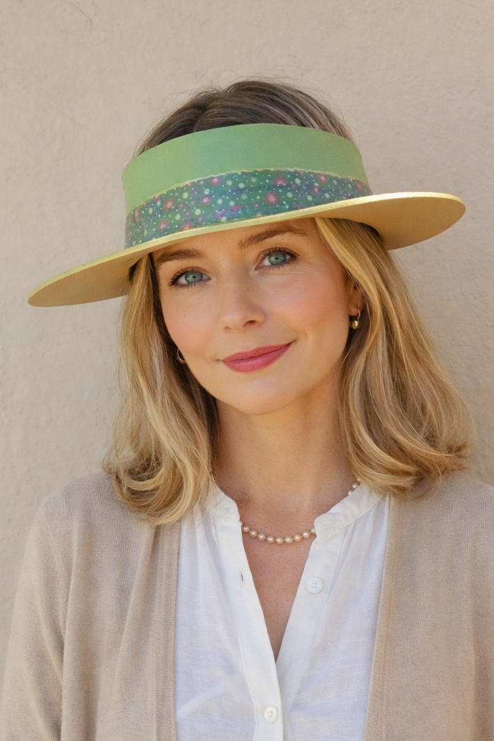 Woman wearing a wide-brimmed hat with a colorful band against a beige background