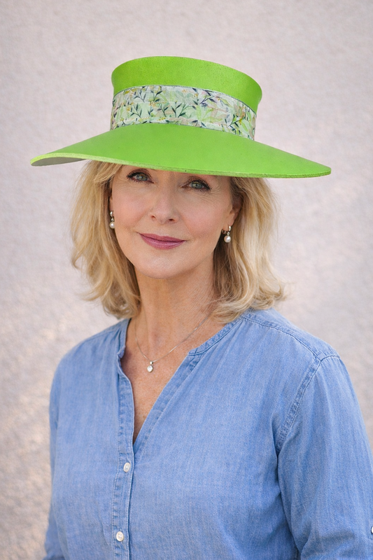 Woman wearing a bright green hat with a floral band against a neutral background