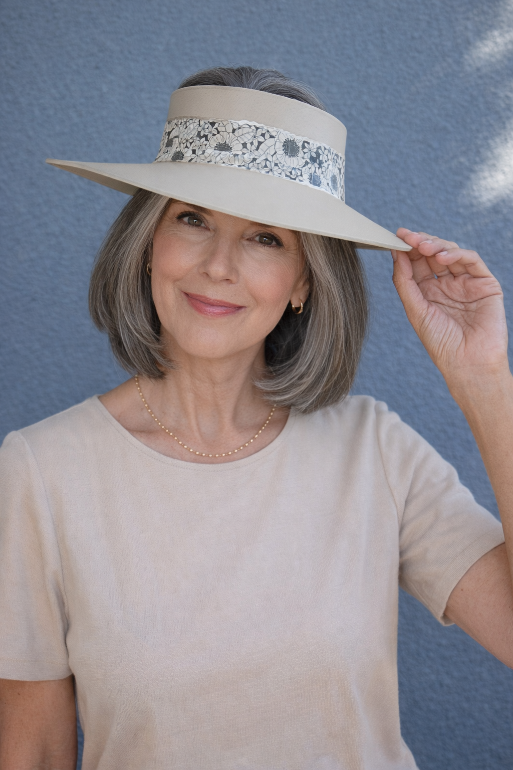 Woman wearing a wide-brimmed hat with decorative band against a blue sky.