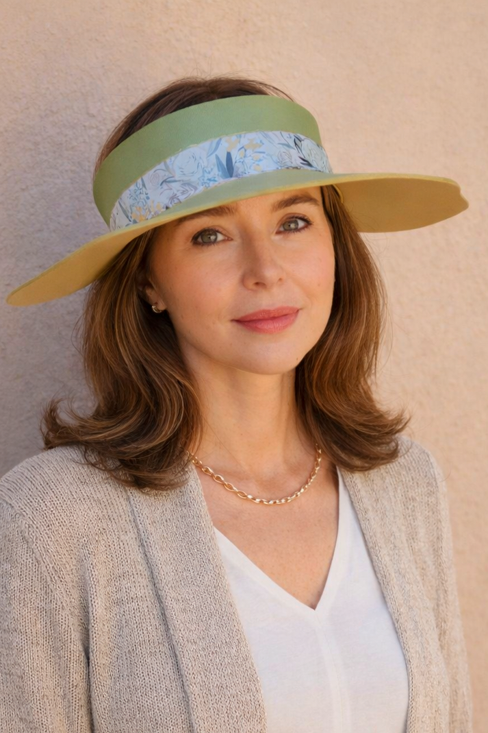 Woman wearing a wide-brimmed hat with a visor against a plain background