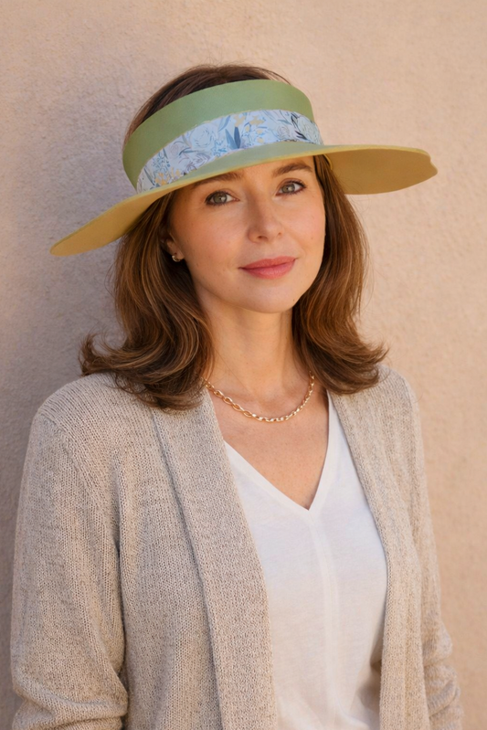 Woman wearing a wide-brimmed hat with a visor against a plain background