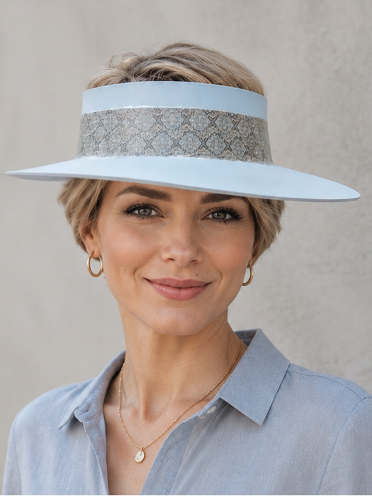 Woman wearing a light blue visor and shirt against a plain background