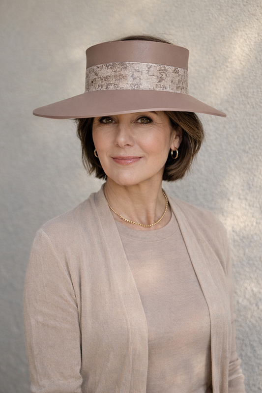 Woman wearing a wide-brimmed hat with decorative band against a neutral background