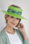 Woman wearing a green visor with floral pattern on a plain background