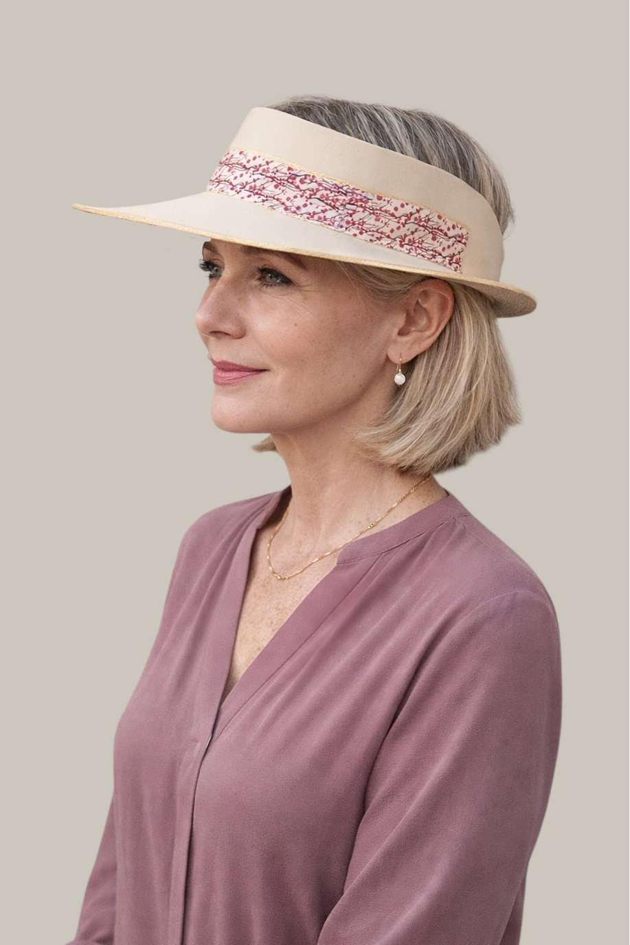 Woman wearing a visor with a decorative band on a plain background