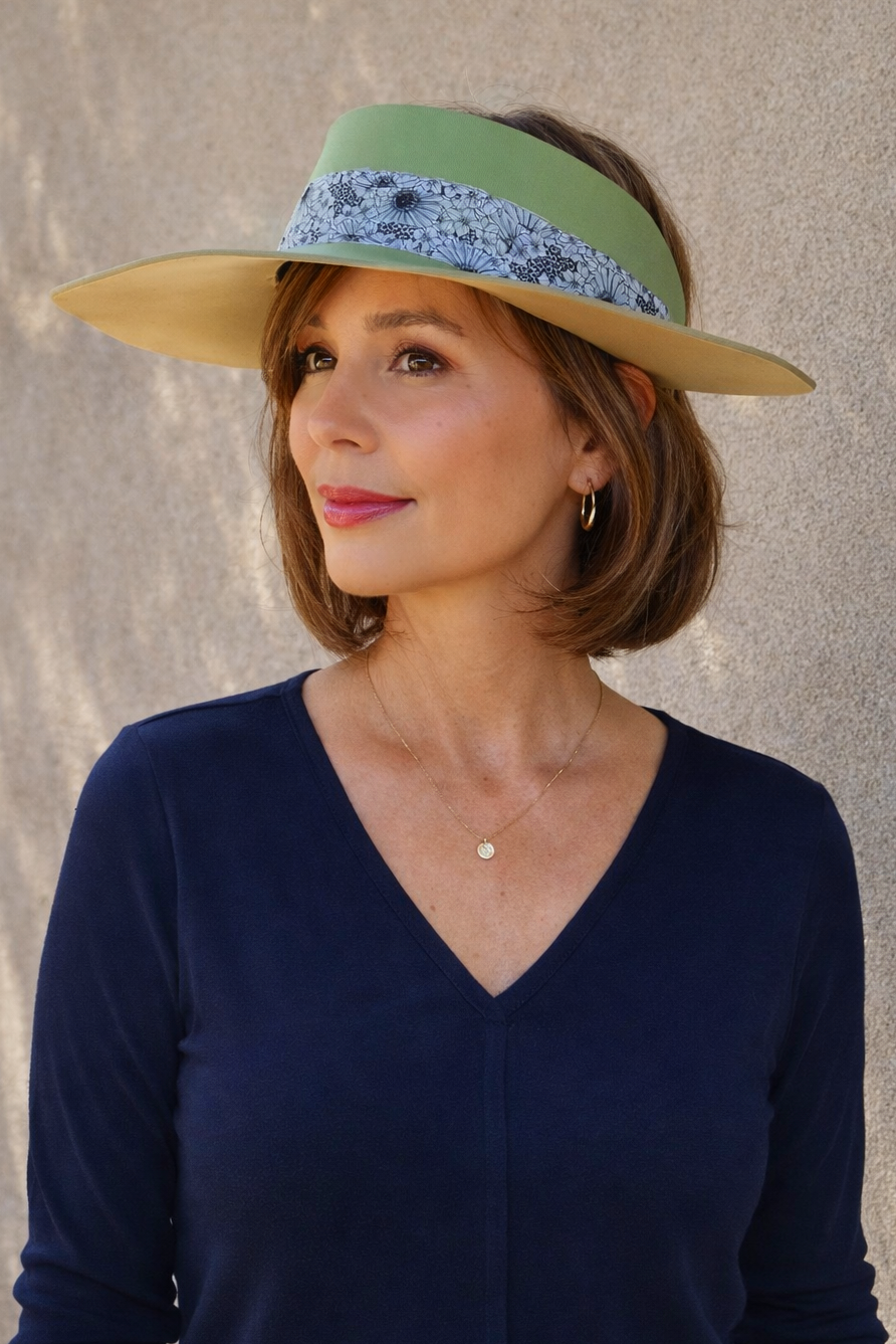 Woman wearing a wide-brimmed hat with a decorative band against a neutral background