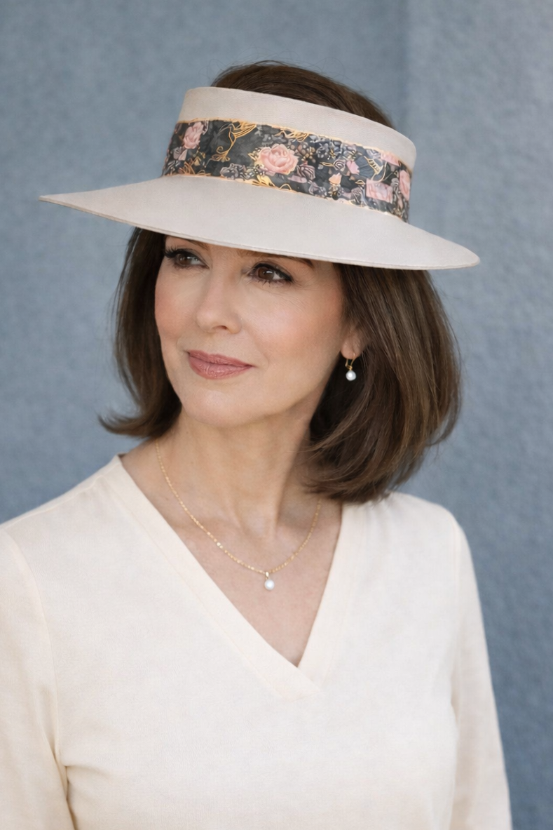 Woman wearing a white hat with floral band against a blue background