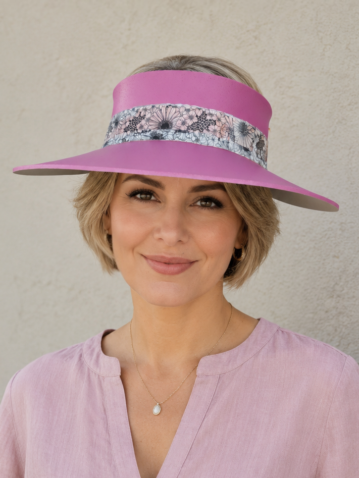 Woman wearing a pink visor and matching blouse against a neutral background