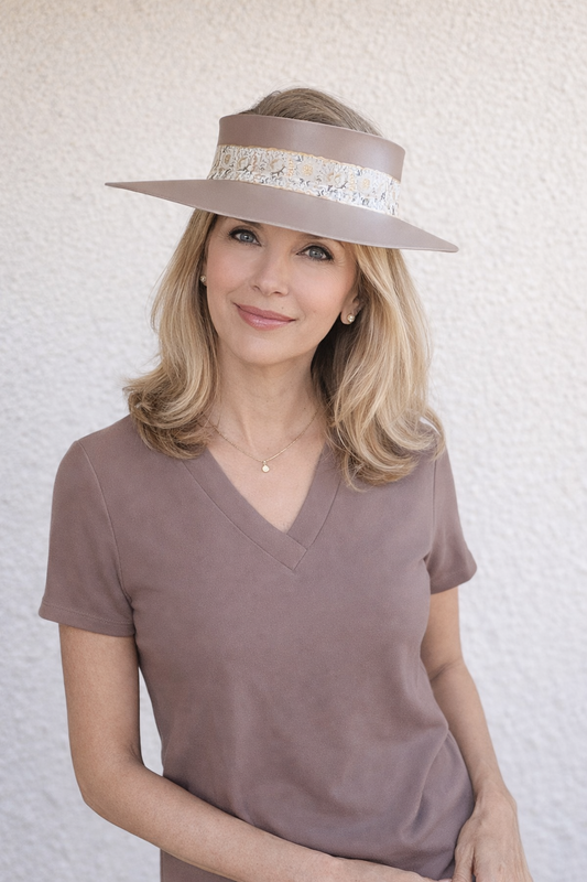Woman wearing a wide-brimmed hat with a decorative band against a light background