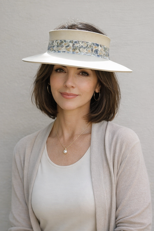 Woman wearing a wide-brimmed hat with floral band against a plain background