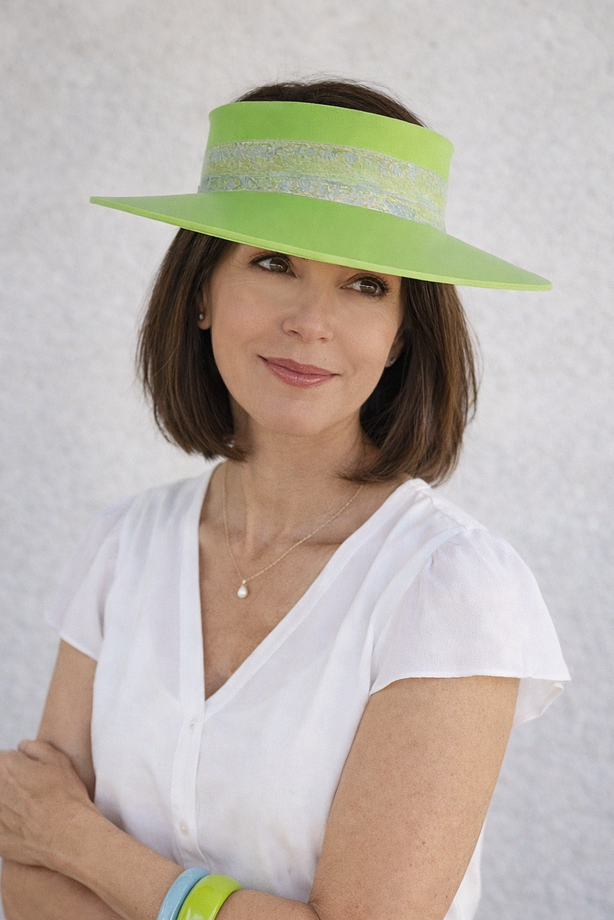 Woman wearing a bright green visor and wristbands against a light background