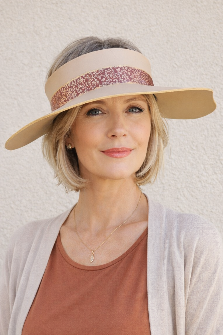 Woman wearing a beige visor and brown top against a light background