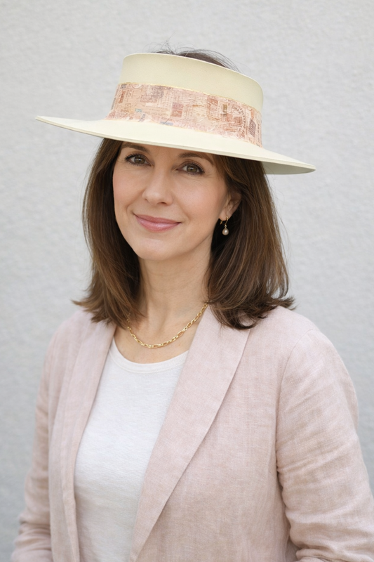 Woman wearing a beige hat with a wide brim against a plain background