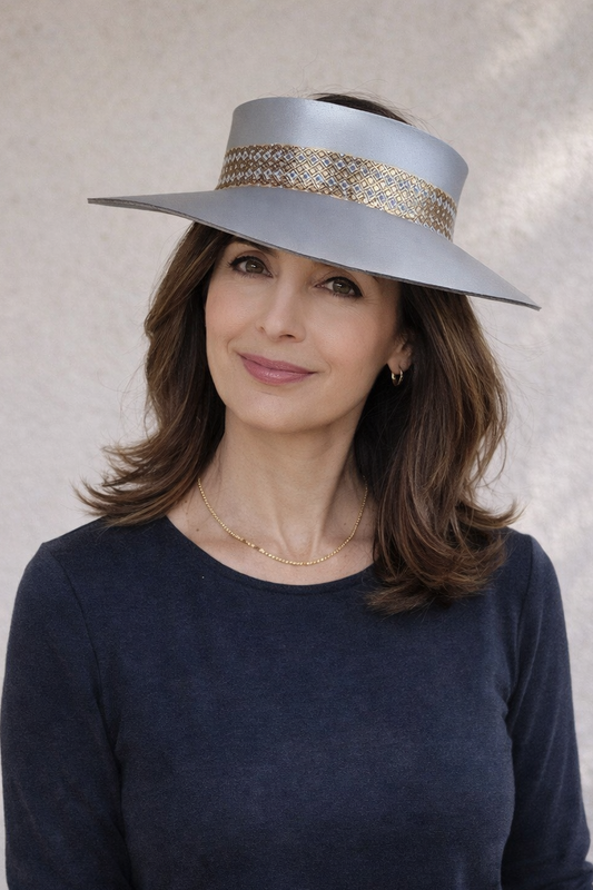 Woman wearing a wide-brimmed hat with a decorative band against a neutral background