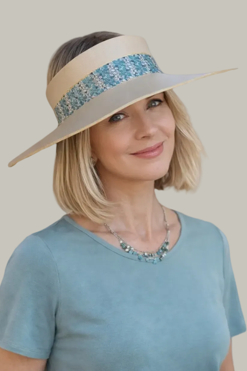 Woman wearing a beige sun hat with a blue decorative band on a white background