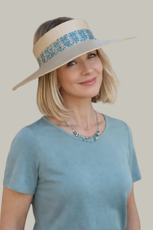 Woman wearing a beige sun hat with a blue decorative band on a white background