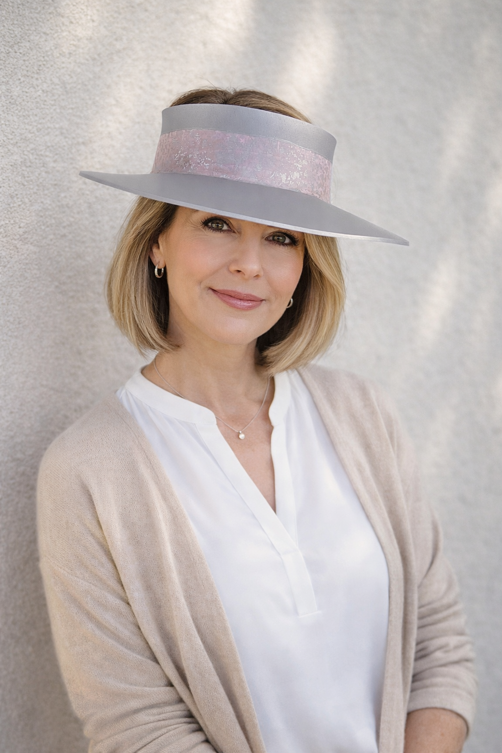 Woman wearing a wide-brimmed hat against a neutral background