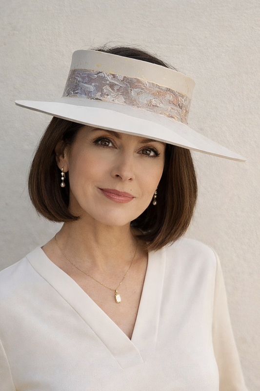 Woman wearing a white hat with a decorative band against a plain background