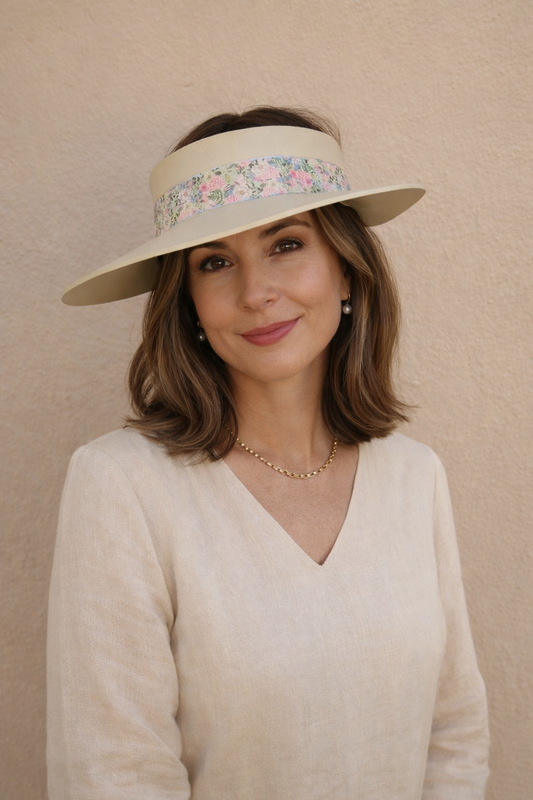 Woman wearing a wide-brimmed hat with floral band against a beige background