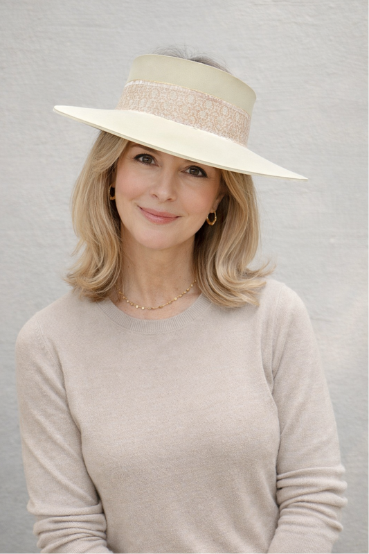 Woman wearing a beige hat against a gray background