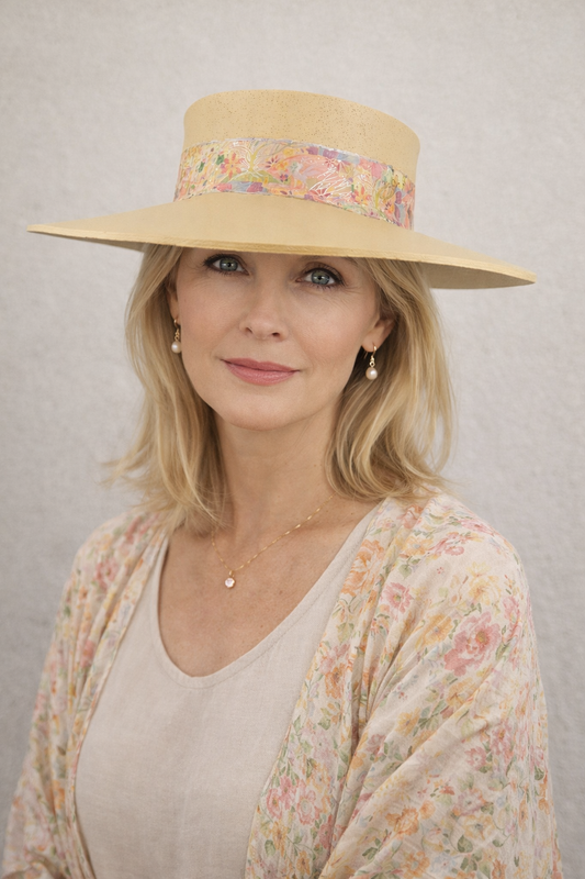 Woman wearing a wide-brimmed hat with floral band against a plain background