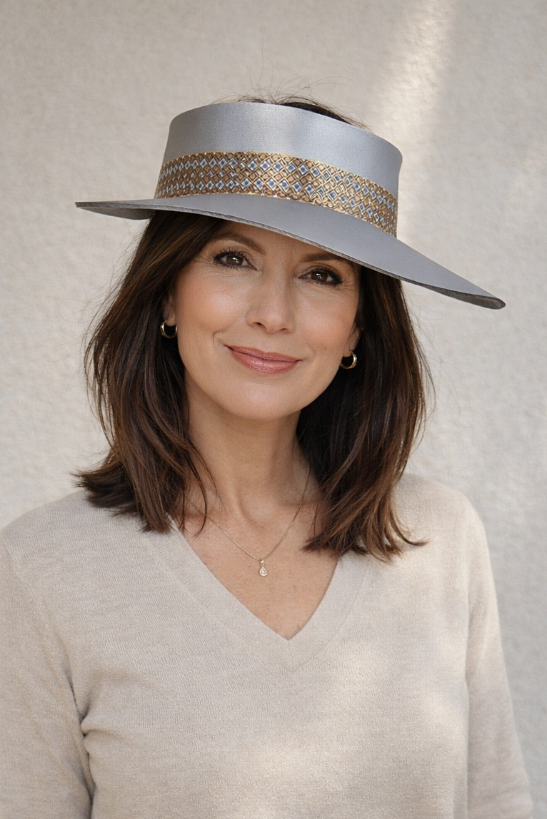 Woman wearing a wide-brimmed hat with a decorative band against a neutral background