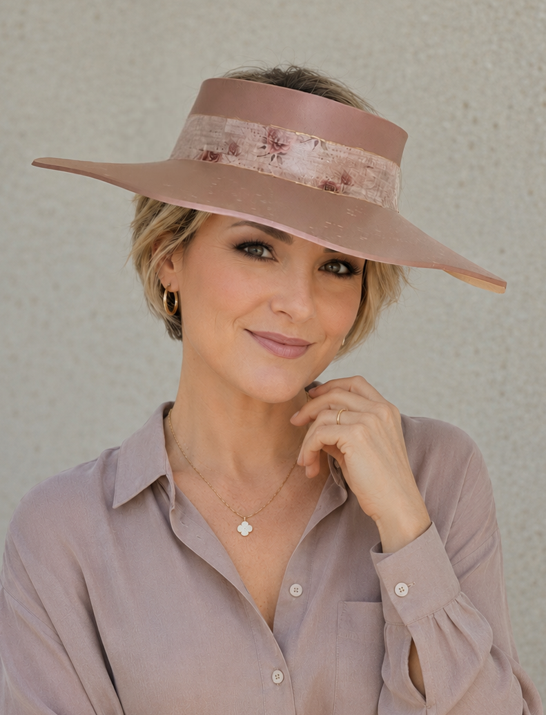 Woman wearing a wide-brimmed hat and light purple shirt against a neutral background