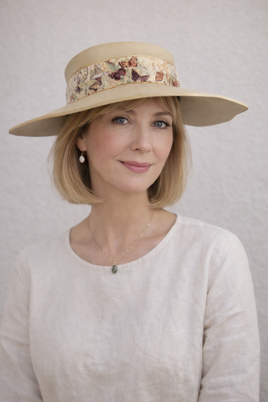 Woman wearing a beige hat with a floral band against a plain background