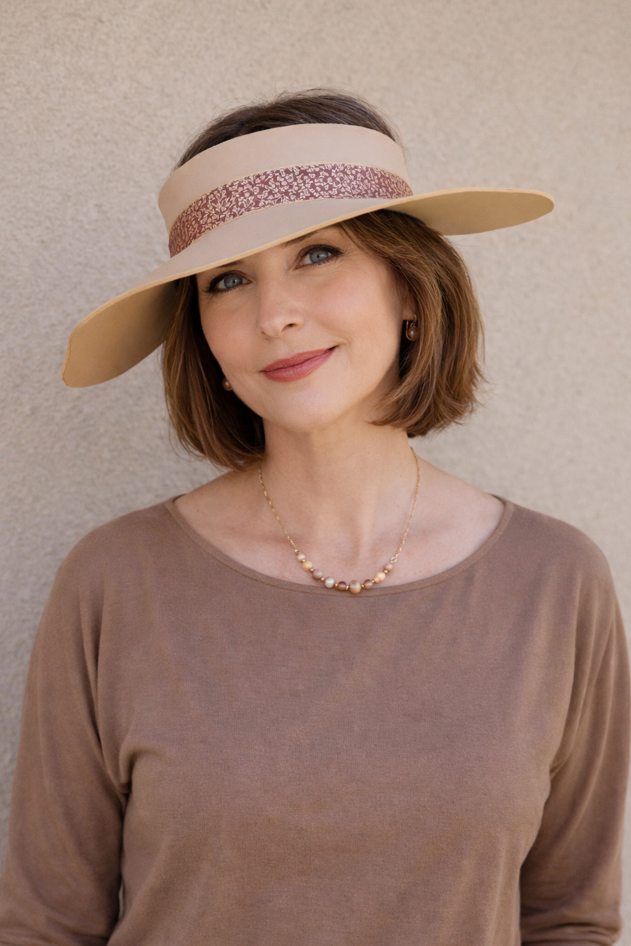 Woman wearing a wide-brimmed hat with a neutral background