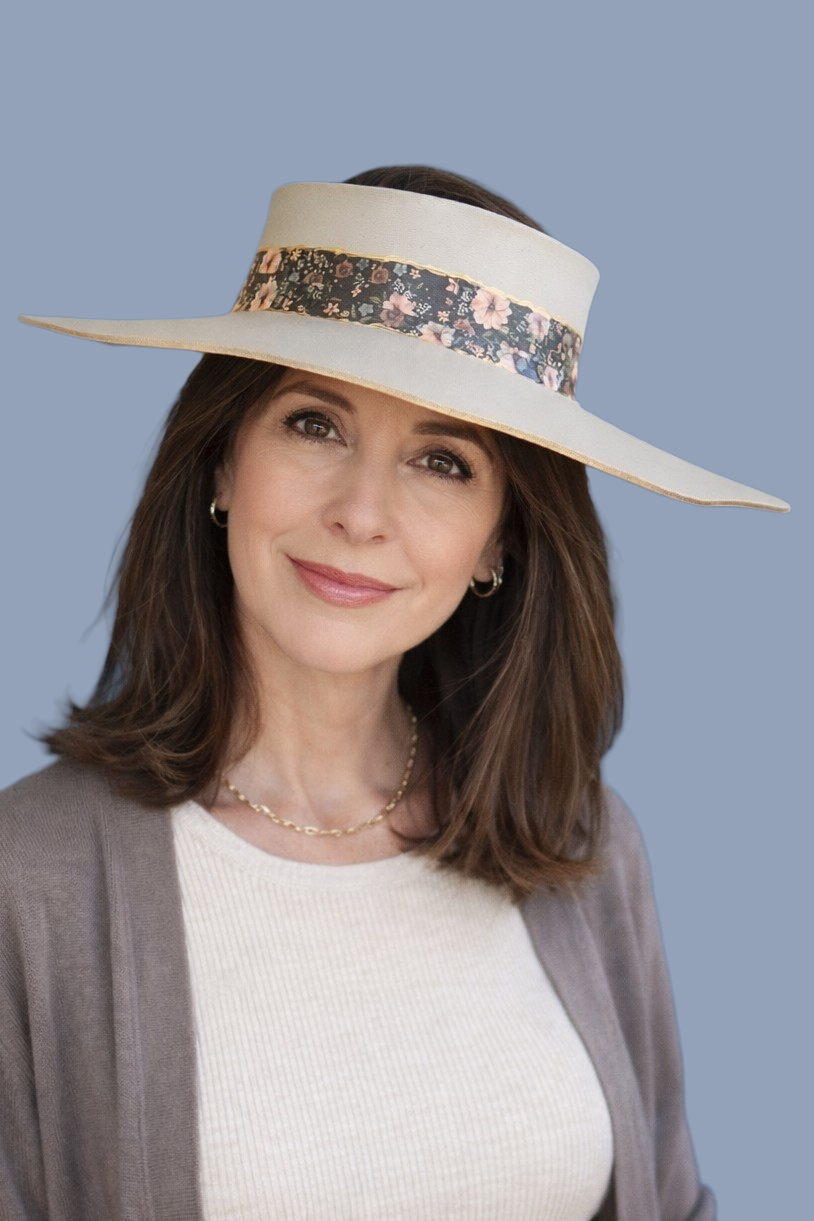 Woman wearing a wide-brimmed hat with floral band against a blue background