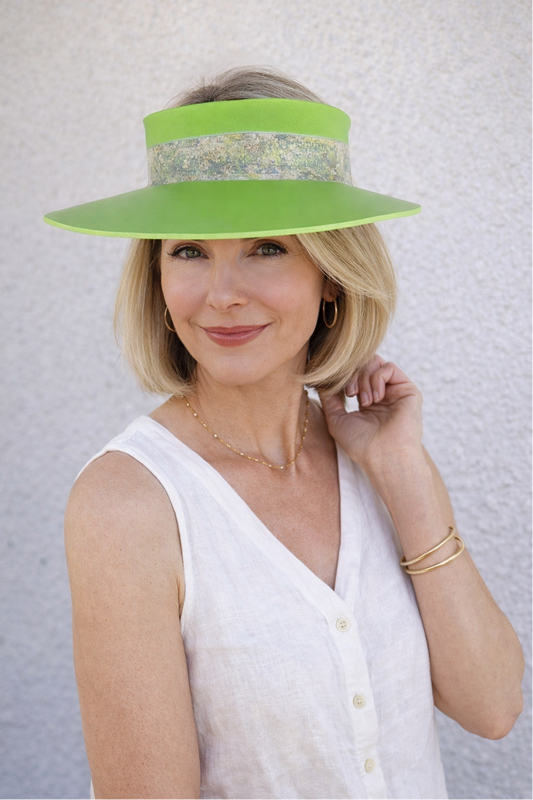 Woman wearing a bright green visor against a light background